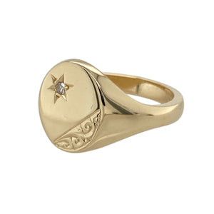 Bring refined detail and classic presence to your collection with this pre-owned 9ct yellow gold and diamond set engraved signet ring—a bold yet elegant piece with timeless character.

Design: The ring features a 14mm high oval head with fine engraving and a single diamond accent, adding a subtle touch of sparkle to the traditional signet style.
Material: Made from 9-carat yellow gold, the polished finish enhances the engraved detail and gives the ring a warm, lustrous glow.
