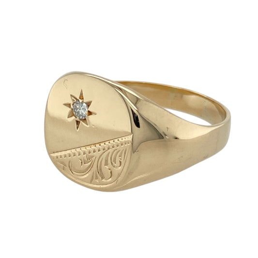 Add distinguished style and a refined finish to your collection with this pre-owned 9ct yellow gold and diamond set engraved corner signet ring—bold in presence with a touch of sparkle.

Design: The ring features a 14mm high rectangular face with classic engraving and a single diamond accent on the corner, blending tradition with subtle brilliance.
Material: Made from 9-carat yellow gold, the polished finish enhances the engraved detail and provides a rich, timeless glow.
