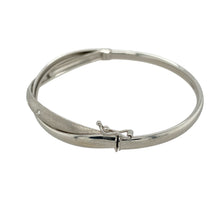 Load image into Gallery viewer, Add modern elegance and subtle sparkle to your collection with this pre-owned 9ct white gold cubic zirconia set crossover bangle—contemporary in design and perfect for everyday sophistication.

Design: The bangle features a stylish crossover front where two 4mm bands intersect—one polished and set with cubic zirconia for sparkle, the other with a brushed finish for contrast and texture.

