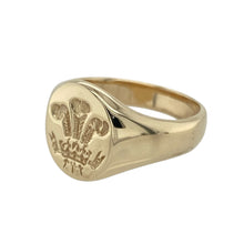 Load image into Gallery viewer, Showcase heritage and bold design with this pre-owned 9ct yellow gold three feather oval signet ring—perfect for classic styling with symbolic significance.

Design: The ring features a 13mm high oval face engraved with the iconic Welsh three feather emblem, offering a proud and timeless motif.
Material: Made from 9-carat yellow gold, the polished finish enhances the fine engraving and adds a warm, rich glow.

