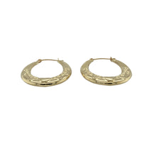 Load image into Gallery viewer, Add sweet detail and classic shine to your collection with these pre-owned 9ct yellow gold heart patterned oval creole earrings—perfect for delicate charm with everyday appeal.

Design: Each earring features an oval creole shape adorned with a subtle heart pattern, blending timeless form with romantic detail.
Material: Made from 9-carat yellow gold, the polished finish highlights the design and adds a soft, radiant glow.

