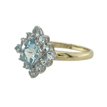 Load image into Gallery viewer, Bring vibrant colour and vintage-inspired sparkle to your collection with this pre-owned 9ct yellow gold cluster ring set with aqua-coloured stones—a bold and elegant design with timeless appeal.

Design: This eye-catching ring features a central square-cut aqua-coloured stone, surrounded by a halo of round-cut stones in a classic cluster arrangement, with a 15mm high front for standout presence.

