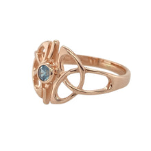 Load image into Gallery viewer, Bring heritage beauty and gentle colour to your collection with this pre-owned 9ct rose gold Clogau ring set with blue topaz—a graceful design blending Celtic tradition with elegant sparkle.

Design: This ring features a 3mm round blue topaz nestled within an intricate Celtic knot design, with a 12mm high front that offers standout detail and symbolic charm.
Material: Made from 9-carat rose gold, the warm tone enhances the soft blue of the topaz and highlights the flowing knotwork design.

