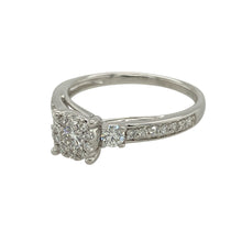 Load image into Gallery viewer, Bring refined sparkle and modern elegance to your collection with this pre-owned 9ct white gold and diamond illusion set solitaire ring—a timeless design with impressive brilliance.

Design: This ring features a brilliant-cut diamond surrounded by a halo of smaller diamonds, creating the illusion of a larger central stone. The look is completed with a half diamond-set band for added shimmer.

