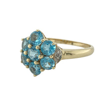 Load image into Gallery viewer, Add a touch of floral sparkle and vibrant colour to your collection with this pre-owned 9ct yellow gold diamond and blue topaz set flower cluster ring—a graceful and eye-catching design perfect for everyday elegance or special occasions.

Design: The 13mm high front features a flower-shaped cluster of 4mm diameter blue topaz stones, accented by a small diamond on either side to enhance the brilliance and balance of the piece.
 
