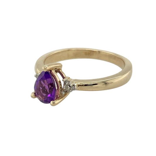 Add a touch of colour and sparkle to your collection with this pre-owned 9ct yellow gold amethyst and cubic zirconia set ring—a graceful design with classic elegance and a hint of glamour.

Design: The ring features a 7mm by 5mm teardrop-shaped amethyst at the centre, accented by small clusters of cubic zirconia stones on either side for added brilliance.
Material: Made from 9-carat yellow gold, the polished finish enhances the rich purple hue of the amethyst and the sparkle of the surrounding stones.
