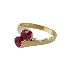 Load image into Gallery viewer, Add rich colour and flowing elegance to your jewellery collection with this pre-owned 9ct yellow gold double ruby set twist over ring—a bold and graceful design with timeless appeal.

Design: The ring features two 5mm diameter round ruby stones in a twist over setting, creating a fluid and balanced design with vibrant red hues.
Material: Made from 9-carat yellow gold, the polished finish complements the deep colour of the rubies and enhances the ring’s sculptural shape.


