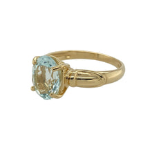 Load image into Gallery viewer, Bring vibrant elegance and refined colour to your collection with this pre-owned 18ct yellow gold and oval aqua coloured stone set ring, offering a striking design and sophisticated presence—perfect for adding a fresh touch to any look.

Design: The ring features a beautiful oval aqua coloured stone measuring 10mm by 8mm, creating a bold and eye-catching focal point. The soft, serene hue of the stone is elegantly complemented by the warm glow of yellow gold, making it a standout statement piece.

