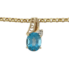 Load image into Gallery viewer, Bring serene colour and refined sparkle to your collection with this pre-owned 9ct yellow gold diamond and blue topaz set pendant on a 20&quot; belcher chain necklace, offering a striking blend of timeless elegance and eye-catching detail—perfect for any occasion.

Design: The pendant features a vibrant oval blue topaz stone measuring 10mm by 8mm, accented by shimmering diamonds, creating a bright and captivating focal point that measures 1.8cm long.

