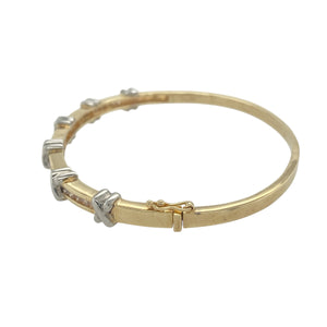 Bring elegant sparkle and romantic detail to your collection with this pre-owned 9ct yellow and white gold diamond channel set kisses pattern bangle, offering a beautiful blend of timeless design and meaningful charm—perfect for making a graceful statement.

Design: The bangle features an intricate kisses pattern adorned with channel set diamonds, adding a touch of brilliance and a romantic motif throughout the design.
