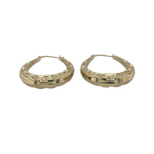 Load image into Gallery viewer, Bring elegant detail and timeless style to your collection with these pre-owned 9ct yellow gold patterned oval creole earrings—a refined design with classic charm and everyday versatility.

Design: The earrings feature an oval creole shape with engraved patterns, offering a graceful silhouette enhanced by subtle texture and shine.
Material: Made from 9-carat yellow gold, the polished finish highlights the decorative pattern while adding a warm, golden glow.

