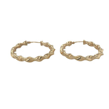 Load image into Gallery viewer, Bring graceful movement and timeless elegance to your collection with these pre-owned 9ct yellow gold ribbon twist hoop creole earrings—a classic design elevated by soft curves and subtle texture.

Design: The earrings feature a hoop creole shape with a ribbon-like twist, creating gentle contours that reflect the light and add fluidity to the form.
Material: Made from 9-carat yellow gold, the polished finish enhances the sculptural twist and gives a warm, radiant glow.

