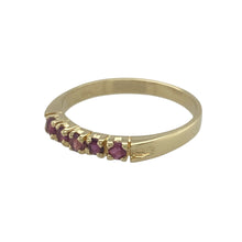 Load image into Gallery viewer, Bring rich colour and timeless warmth to your jewellery collection with this pre-owned 18ct yellow gold and ruby band ring—offering refined elegance with a touch of bold charm.

Design: A row of 2mm round-cut rubies is set evenly along the band, adding vibrant red sparkle in a sleek, classic layout.
Material: Made from 18-carat yellow gold, the high-quality finish complements the intensity of the rubies for a luxurious and lasting impression.

