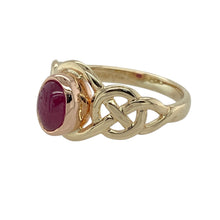Load image into Gallery viewer, Celebrate heritage and colour with this pre-owned 9ct yellow and rose gold Clogau Celtic ring, featuring a rich cabochon ruby in a timeless, symbolic design.

Design: The ring showcases a 6mm by 4mm oval cabochon ruby at the centre, framed by elegant Celtic knotwork that reflects unity and tradition.
Material: Made from 9-carat yellow gold with rose gold detailing, the piece includes rare Welsh gold, a hallmark of Clogau’s signature craftsmanship.

