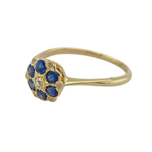 Load image into Gallery viewer, Add floral charm and timeless sparkle to your collection with this pre-owned 18ct yellow gold diamond and sapphire cluster ring—delicate, elegant, and full of vintage appeal.

Design: The front of the ring measures 8mm high and features a classic flower cluster arrangement with 2mm round sapphires encircling a central diamond for a refined, symmetrical look.
Material: Made from 18-carat yellow gold, the polished finish enhances the rich blue of the sapphires and the sparkle of the diamond.

