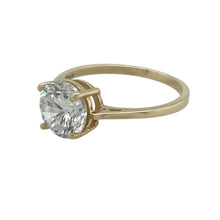 Load image into Gallery viewer, Bright and eye-catching, this pre-owned 9ct yellow gold solitaire ring offers classic elegance with a bold centrepiece—perfect for adding sparkle to everyday wear or marking a special moment.

Design: The ring features a single round cubic zirconia measuring 8mm in diameter, held in a traditional solitaire setting for maximum brilliance and timeless appeal.
Material: Made from 9-carat yellow gold, the polished band provides a warm, classic contrast to the clear sparkle of the stone.


