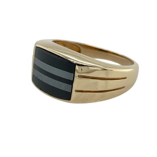 Distinctive and bold, this pre-owned 9ct yellow gold signet ring features a unique striped inlay—perfect for those who appreciate statement design with a refined edge.

Design: The ring showcases an 11mm high rectangular face with alternating stripes in hematite and onyx style, creating a striking contrast and modern geometric appeal.
Material: Made from 9-carat yellow gold, the polished finish enhances the depth of the dark inlay and gives the ring a luxurious tone.
