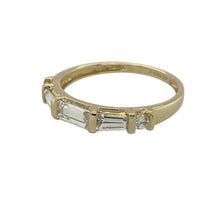 Load image into Gallery viewer, Elegant and subtly detailed, this pre-owned 14ct yellow gold band ring combines classic sparkle with a refined profile—perfect for everyday wear or marking a special moment.

Design: The ring features a 3mm wide band set with two brilliant-cut cubic zirconia stones and three baguette-cut stones, offering a mix of sparkle and clean geometry.
Material: Made from 14-carat yellow gold, the polished finish adds warmth and complements the clear brilliance of the stones.


