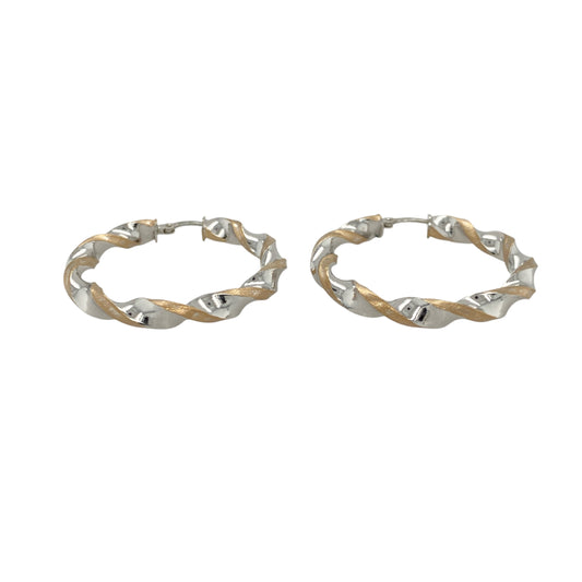 Elegant and eye-catching, these pre-owned 9ct yellow and white gold twisted hoop creole earrings feature a fluid two-tone design—perfect for versatile styling with a modern twist.

Design: Each earring showcases a classic hoop with an elegant twist, blending yellow and white gold in an intertwined design for subtle contrast and movement.
Material: Made from 9-carat yellow and white gold, the polished finish enhances the flowing curves and highlights the soft interplay of tones.
