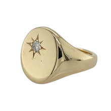 Load image into Gallery viewer, Bold and distinguished, this pre-owned 9ct gold oval signet ring features a refined design with a sparkling diamond accent—perfect for classic styling with a luxurious edge.

Design: The ring showcases a large 17mm high oval face with a single diamond starburst set in the corner, adding a subtle yet striking touch of brilliance.
Material: Made from 9-carat gold, the smooth polished finish enhances the bold shape and highlights the elegant diamond detail.

