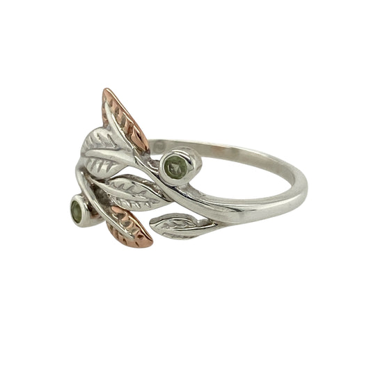 Bring natural beauty and soft colour to your jewellery collection with this pre-owned 925 silver Clogau leaf ring, featuring 9ct rose gold detailing and a vibrant peridot—perfect for everyday elegance with a touch of Welsh charm.

Design: The ring showcases a flowing leaf design measuring 13mm high at the front, accented with 9ct rose gold detailing and a bright green peridot nestled at the centre.

