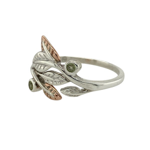 Bring natural beauty and soft colour to your jewellery collection with this pre-owned 925 silver Clogau leaf ring, featuring 9ct rose gold detailing and a vibrant peridot—perfect for everyday elegance with a touch of Welsh charm.

Design: The ring showcases a flowing leaf design measuring 13mm high at the front, accented with 9ct rose gold detailing and a bright green peridot nestled at the centre.

