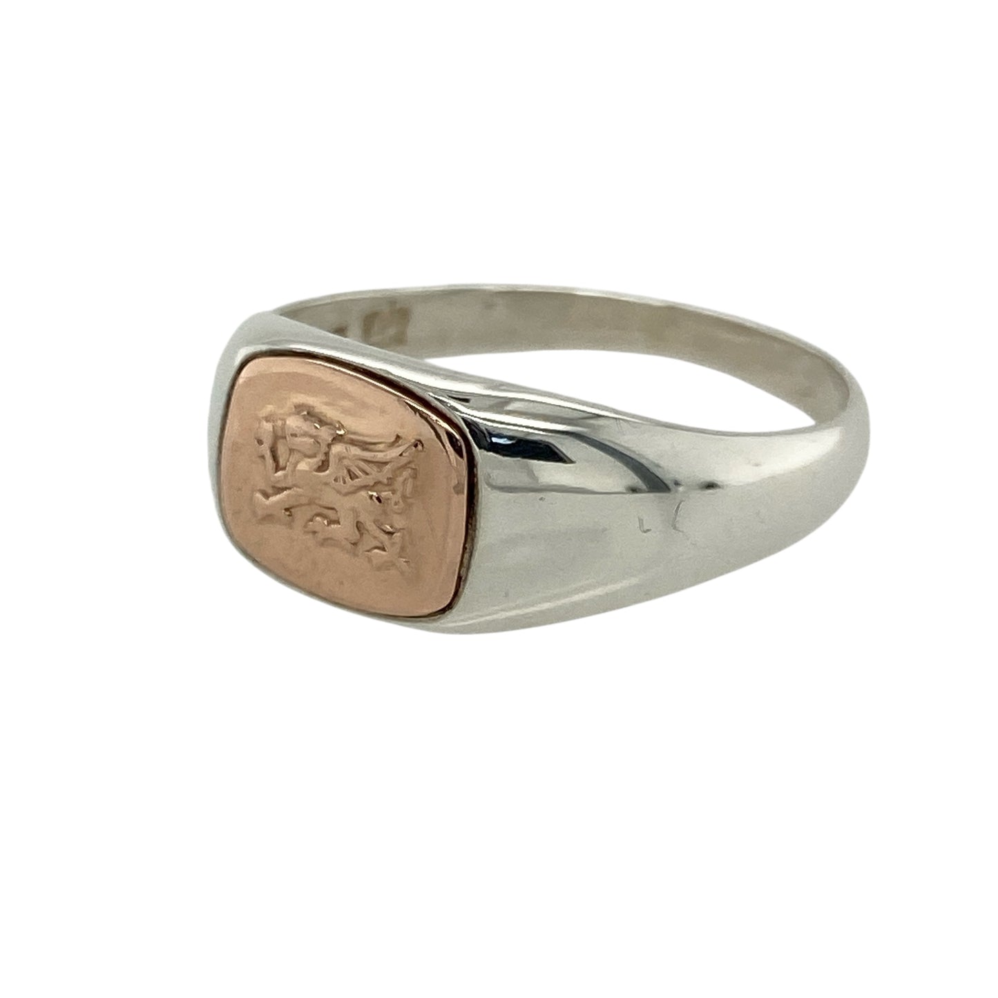 Bring bold heritage and national pride to your jewellery collection with this pre-owned 925 silver Clogau signet ring, featuring the iconic Welsh Dragon in 9ct rose gold—perfect for a striking symbol of identity and strength.

Design: The ring features an 8mm high oval front engraved with the detailed Welsh Dragon, highlighted in polished 9ct rose gold for strong contrast and lasting impact.
