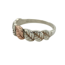 Load image into Gallery viewer, Bring natural elegance and symbolic beauty to your jewellery collection with this pre-owned 925 silver Clogau leaf band ring, featuring 9ct rose gold detailing—perfect for everyday sophistication with a touch of Welsh heritage.

Design: The ring features a flowing leaf pattern across the front of the 7mm wide band, accented with polished 9ct rose gold to highlight the organic lines and graceful movement.

