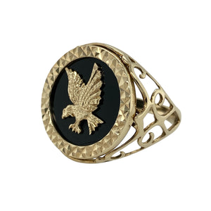 Bring bold symbolism and striking contrast to your jewellery collection with this pre-owned 9ct gold eagle signet ring, featuring a deep onyx background and open patterned shoulders—perfect for a confident, statement look.

Design: The ring features a 22mm high face with a detailed gold eagle set against a polished black onyx backdrop, creating a powerful and eye-catching centrepiece.
