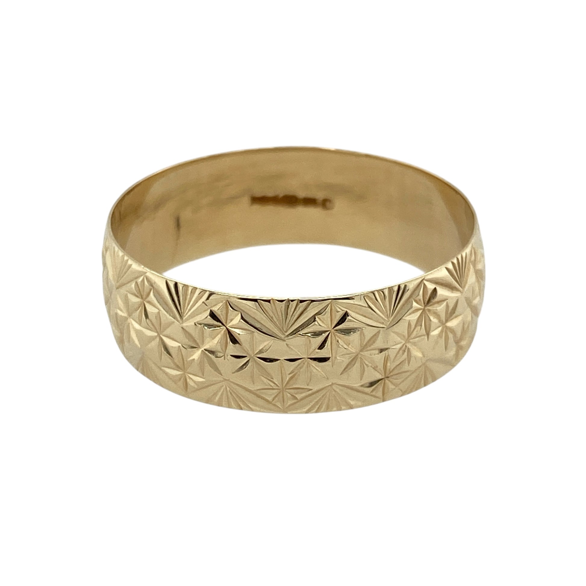 Bring classic style and subtle texture to your jewellery collection with this pre-owned 9ct yellow gold patterned band ring—perfect for timeless everyday wear.

Design: The ring features a 7mm wide band with fine patterned detailing, adding depth and visual interest to the simple silhouette.
Material: Made from 9-carat yellow gold, the polished finish enhances the warm golden tone and highlights the textured design.
