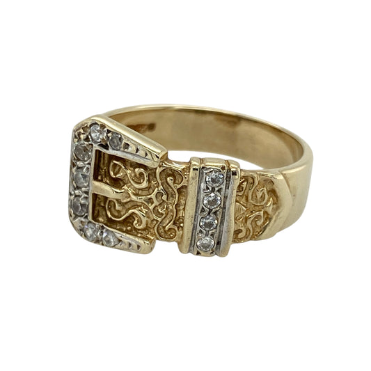 Bring vintage charm and sparkling detail to your collection with this pre-owned 9ct yellow gold cubic zirconia patterned buckle ring—perfect for adding a unique and symbolic touch to your style.

Design: The ring features a 12mm high buckle design at the front, adorned with cubic zirconia stones that add light and brilliance to the patterned detailing.
Material: Made from 9-carat yellow gold, the polished finish enhances the warm tone of the metal and highlights the intricate buckle motif.

