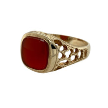 Load image into Gallery viewer, Bring vintage warmth and bold design to your collection with this pre-owned 9ct yellow gold carnelian signet ring—perfect for making a statement with timeless appeal.

Design: The ring features a rounded square carnelian measuring approximately 9.5mm by 9.5mm, framed by open patterned shoulders for added detail.
Material: Made from 9-carat yellow gold, the polished finish enhances the rich reddish-brown hue of the carnelian.

