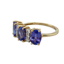 Load image into Gallery viewer, Bring vibrant colour and elegant sparkle to your collection with this pre-owned 14ct yellow gold diamond and tanzanite ring—perfect for special occasions or adding a touch of luxury to everyday wear.

Design: The ring features three oval tanzanite stones, each measuring 8mm by 6mm, with diamonds set in between for added brilliance and contrast.
Material: Made from 14-carat yellow gold, the polished finish enhances the rich purple-blue tones of the tanzanite and the sparkle of the diamonds.

