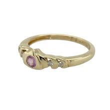 Load image into Gallery viewer, Bring feminine colour and refined sparkle to your collection with this pre-owned 9ct yellow gold diamond and pink sapphire ring—perfect for adding a delicate yet distinctive touch to any look.

Design: The ring features a 3mm round pink sapphire at the centre, accented by diamonds for added brilliance and contrast.
Material: Made from 9-carat yellow gold, the polished finish enhances the warm tone and complements the vibrant pink of the sapphire.

