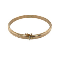 Load image into Gallery viewer, Bring timeless style and golden elegance to your collection with this pre-owned 9ct yellow gold ridged hinged bangle—an effortlessly chic piece perfect for both everyday wear and special occasions.

Design: The bangle features a plain ridged pattern with a hinged opening, combining subtle detail with practical wearability.
Material: Made from 9-carat yellow gold, the polished finish enhances its warm tone and classic appeal.
 
