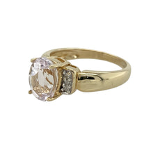 Load image into Gallery viewer, Bring vibrant colour and refined sparkle to your collection with this pre-owned 9ct yellow gold diamond and pink stone ring—a striking design with timeless elegance.

Design: The ring showcases a 9mm by 7mm oval pink stone at the centre, accented by small diamonds on either side for added brilliance.
Material: Made from 9-carat yellow gold, the polished finish enhances the warmth of the gold and complements the vivid pink stone.

