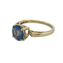 Load image into Gallery viewer, Bring vibrant colour and refined sparkle to your collection with this pre-owned 9ct yellow gold diamond and blue stone ring—a timeless design with elegant presence.

Design: The ring showcases an 8mm round blue stone at the centre, complemented by small diamonds on the shoulders for added brilliance.
Material: Made from 9-carat yellow gold, the polished finish enhances the deep blue of the centre stone and the sparkle of the diamond accents.

