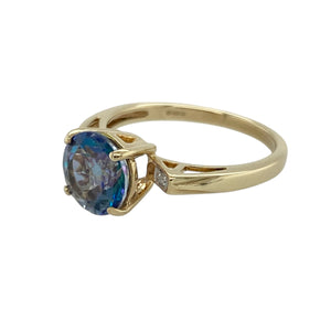 Bring vibrant colour and refined sparkle to your collection with this pre-owned 9ct yellow gold diamond and blue stone ring—a timeless design with elegant presence.

Design: The ring showcases an 8mm round blue stone at the centre, complemented by small diamonds on the shoulders for added brilliance.
Material: Made from 9-carat yellow gold, the polished finish enhances the deep blue of the centre stone and the sparkle of the diamond accents.
