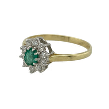 Load image into Gallery viewer, Bring rich colour and refined sparkle to your collection with this pre-owned 18ct yellow gold diamond and emerald cluster ring—a timeless design with elegant character.

Design: The ring showcases a 5mm by 4mm oval emerald at the centre, surrounded by a cluster of diamonds totalling approximately 0.20ct for added brilliance.
Material: Made from 18-carat yellow gold, the polished finish enhances the deep green of the emerald and the sparkle of the diamonds.

