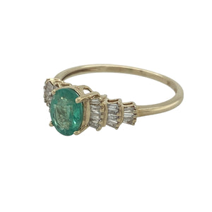 Bring vibrant colour and refined sparkle to your collection with this pre-owned 9ct yellow gold diamond and emerald ring—a timeless design with elegant character.

Design: The ring features a 7mm by 5mm oval emerald at the centre, framed by three rows of graduating baguette-cut diamonds on each shoulder for added brilliance.
Material: Made from 9-carat yellow gold, the polished finish enhances the deep green of the emerald and the sparkle of the diamonds.
