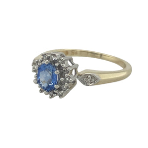 Bring classic elegance and timeless sparkle to your collection with this pre-owned 9ct yellow gold diamond and sapphire cluster ring—a refined piece with enduring charm.

Design: The ring showcases a 5mm by 4mm oval sapphire at the centre, surrounded by a cluster of diamonds that enhance its deep blue hue with brilliant contrast.
Material: Made from 9-carat yellow gold, the polished finish highlights the sapphire’s rich colour and the sparkle of the diamonds.
