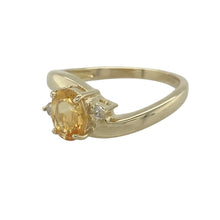 Load image into Gallery viewer, Bring warm colour and refined sparkle to your collection with this pre-owned 9ct yellow gold diamond and citrine twist ring—a vibrant design with timeless elegance.

Design: The ring showcases a 7mm by 5mm oval citrine stone at the centre, accented by diamonds in a graceful twist setting.
Material: Made from 9-carat yellow gold, the polished finish enhances the golden tones of the citrine and the brilliance of the diamonds.

