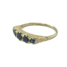 Load image into Gallery viewer, Bring rich colour and classic elegance to your collection with this pre-owned 9ct yellow gold sapphire five-stone ring—a timeless design with refined character.

Design: The ring features five sapphires set across the 5mm wide front of the band, offering balanced style and vibrant blue tones.
Material: Made from 9-carat yellow gold, the polished finish enhances the depth of the sapphires and adds classic appeal.

