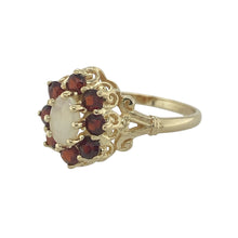 Load image into Gallery viewer, Bring vintage charm and colourful elegance to your collection with this pre-owned 9ct yellow gold opalique and garnet cluster ring—a classic design with timeless appeal.

Design: The ring features a 6mm by 4mm oval opalique stone at the centre, surrounded by deep red garnets in a traditional cluster arrangement.
Material: Made from 9-carat yellow gold, the polished finish enhances the fiery play of colour in the opalique and the rich tones of the garnets.

