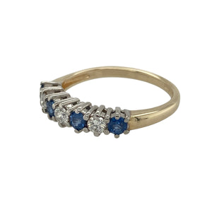 Bring classic elegance and vibrant colour to your collection with this pre-owned 9ct yellow gold sapphire and diamond band ring, offering timeless style with a touch of sparkle—perfect for everyday wear or special occasions.

Design: The ring features round sapphires measuring 3mm in diameter, spaced with diamonds for a balanced and refined look.
Material: Made from 9-carat yellow gold, the polished finish provides a warm contrast to the deep blue sapphires and sparkling diamonds.

