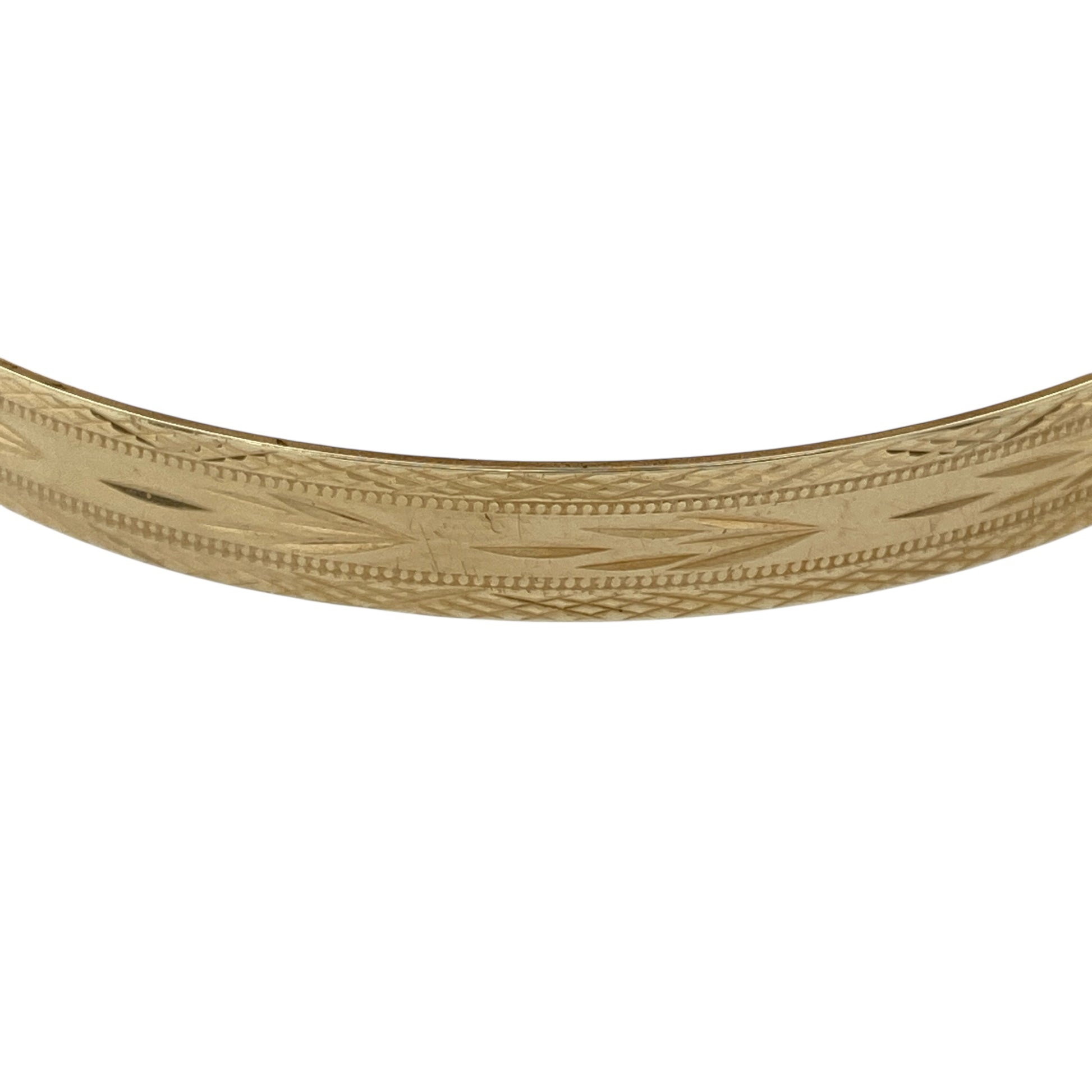 Bring bold elegance and timeless detail to your collection with this pre-owned 9ct yellow gold patterned bangle, offering a substantial design with classic style—perfect for statement wear or everyday sophistication.

Design: The bangle measures 6.7cm in diameter with a 6mm width, detailed with an intricate patterned finish that adds texture and character.
Material: Made from solid 9-carat yellow gold, the polished surface enhances the warm tone and highlights the decorative detail.
