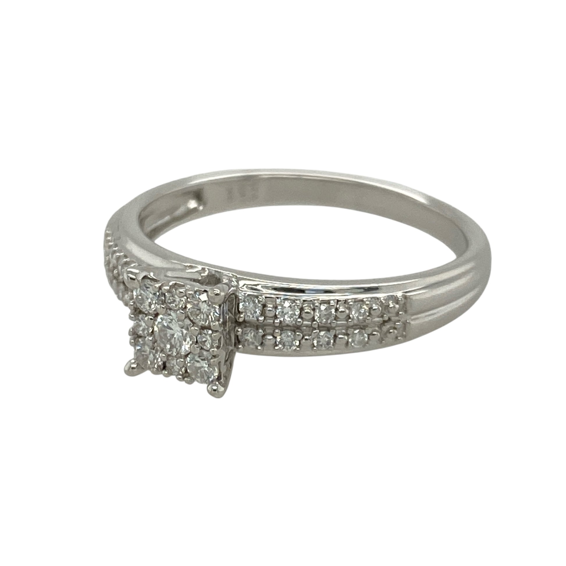 Bring brilliance and sophistication to your collection with this pre-owned 9ct white gold diamond cluster solitaire ring, combining timeless sparkle with a bold princess-style design—perfect for both everyday elegance and special occasions.

Design: The ring features a princess-style cluster arrangement with multiple diamonds, creating the appearance of a larger central stone for maximum impact.
