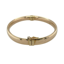 Load image into Gallery viewer, Add classic elegance to your collection with this pre-owned 9ct yellow gold hollow hinged bangle, a timeless accessory with versatile appeal—perfect for everyday wear or special occasions.

Design: The bangle features a smooth polished finish with a hinged opening, combining simplicity with ease of wear.
Material: Made from 9-carat yellow gold, the polished surface enhances the warm tone while the hollow design keeps it lightweight and comfortable.

