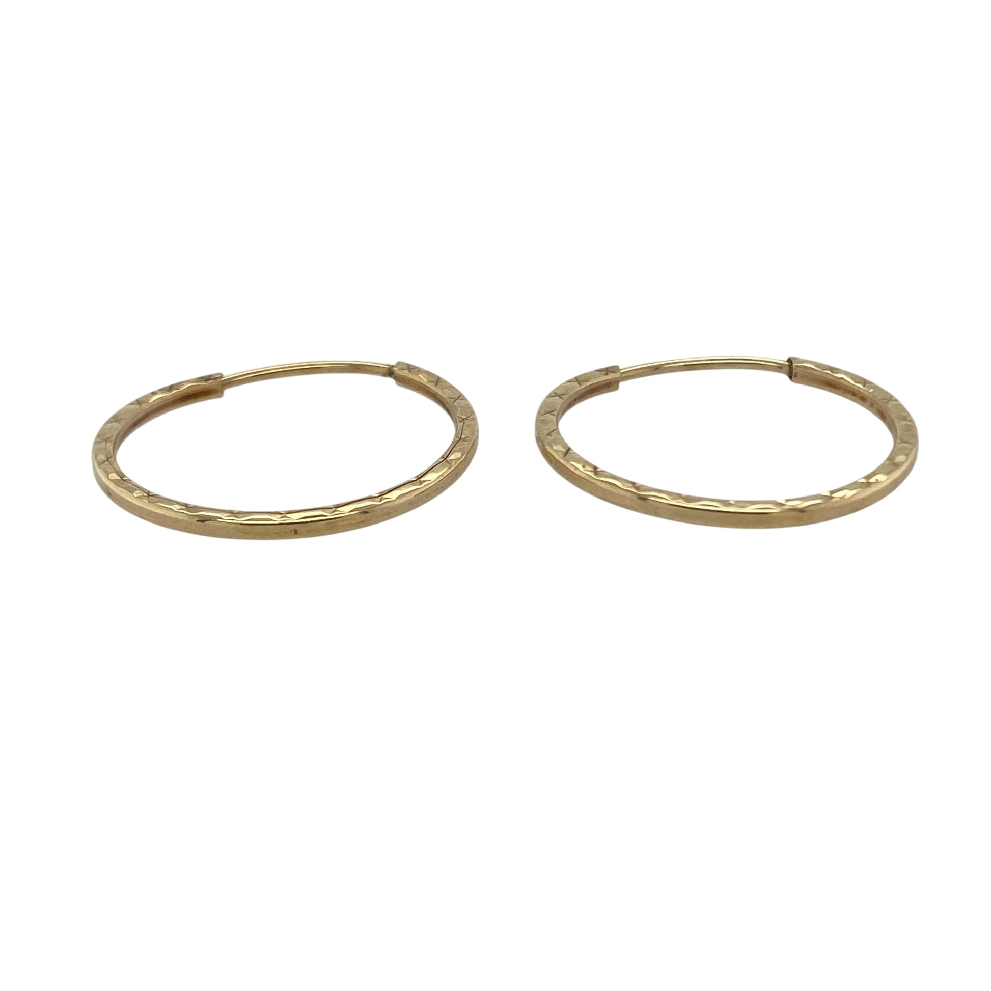 Bring texture and classic shine to your collection with these pre-owned 9ct yellow gold patterned hoop earrings—a timeless design with elegant detail.

Design: Each earring features a traditional hoop shape with a subtle patterned finish, adding depth and character to the polished gold.
Material: Made from 9-carat yellow gold, the polished surface enhances the warm tone and highlights the decorative patterning.