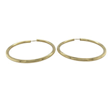 Load image into Gallery viewer, Bring bold simplicity and timeless shine to your collection with these pre-owned 9ct yellow gold hoop earrings, styled in a large plain design for classic appeal.

Design: Each earring features a smooth hollow hoop with a polished finish, offering a sleek and versatile look.
Material: Made from 9-carat yellow gold, the warm golden tone enhances their bold yet refined style.
Earring Detail: The hollow design ensures they remain lightweight while maintaining a statement presence.
